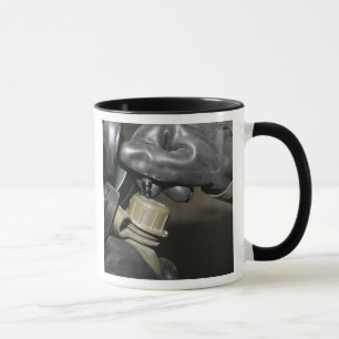 Taza Un infante de marina inserta un tubo de