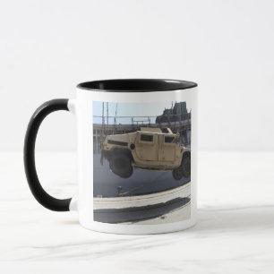 Taza Una grúa levanta una Humvee M998