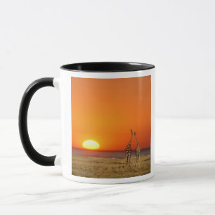 Taza Una pareja de jirafas camina hacia la puesta del s