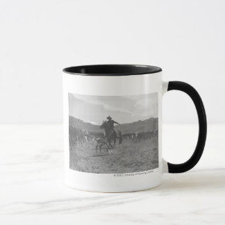 Taza Vaquero roping un becerro para el marcado en