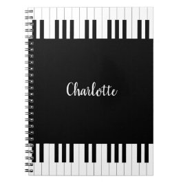 Teclado de piano, cuaderno blanco y negro
