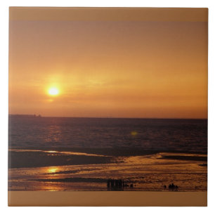 Teja anaranjada de la puesta del sol del océano