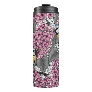 Termo Aves en un jardín de lilas rosadas
