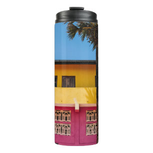 TERMO EDIFICIO DE CONCRETO ROJO Y MARRÓN CERCA DEL ÁRBOL