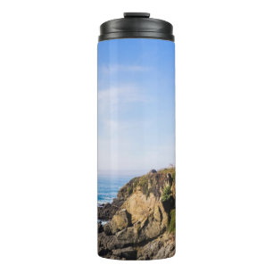 Termo Faro en la colina cielo azul casa blanca océano