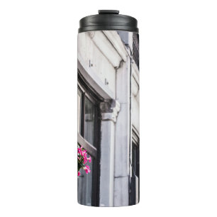 TERMO HANG PINK FLOWER EN EDIFICIO DE CONCRETO BLANCO AL