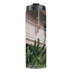 TERMO PLANTA VERDE DE COLOR ROSADO CERCA DEL EDIFICIO