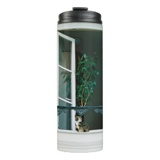 TERMO PLANTA VERDE EN LA VENTANA BLANCA