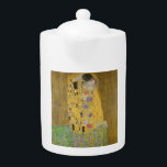 Tetera El abrazo del beso de los amantes por Gustav Klimt<br><div class="desc">La luz del sol brilla por el agitado abrazo dorado que rodea a los amantes de la obra maestra de Gustav Klimt, The Kiss. La escena es una paradoja de intimidad y aislamiento. La pareja está parada en un precipicio, un campo de flores coloridas a sus pies, sin embargo, son...</div>