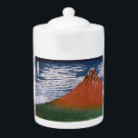 Tetera Fuji Rojo, El Volcán Aka Fujiyama Katsushika Hokus<br><div class="desc">La escena capturada en la huella japonesa de un bloque de madera, "Buen Viento, Limpio Mañana" (también conocida como "Fuji Rojo" o "Aka Fuji"), es una impresionante exhibición del Monte Fuji bañado en los vibrantes tonos del amanecer. Esta obra es parte de la famosa serie de Katsushika Hokusai, "Treinta y...</div>