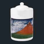 Tetera Fuji Rojo, El Volcán Aka Fujiyama Katsushika Hokus<br><div class="desc">La escena capturada en la huella japonesa de un bloque de madera, "Buen Viento, Limpio Mañana" (también conocida como "Fuji Rojo" o "Aka Fuji"), es una impresionante exhibición del Monte Fuji bañado en los vibrantes tonos del amanecer. Esta obra es parte de la famosa serie de Katsushika Hokusai, "Treinta y...</div>
