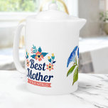 Tetera La mejor madre del mundo | Día de la Madre<br><div class="desc">Sienta tu té favorito con un toque de elegancia y sentimentalidad con esta impresionante tetera "Mejor madre del mundo" adornada con un hermoso diseño de flores de color azul. Las flores azules y las hojas verdes se combinan con el fondo de porcelana blanca, lo que lo convierte en un lugar...</div>