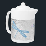 Tetera personalizada de la libélula azul<br><div class="desc">Disfrute de su té con una tetera personalizada de la libélula azul. El diseño de la tetera presenta una libélula colorida, una suave parra blanca y frondosa contra un fondo de damasco gris claro con un área para personalizar con tu nombre. Artículos de regalo adicionales disponibles con este diseño así...</div>