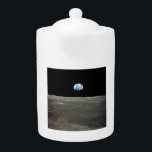Tetera Tierra desde la luna en el espacio negro: Surco<br><div class="desc">Desde las llanuras lunares desoladas, la Tierra pende como un frágil ornamento en el abismo. El contraste crudo entre los grises estériles del paisaje lunar y el mármol azul vibrante de la Tierra enciende una punzada de extranjería dentro de la luna. Innumerables noches había presenciado a la Tierra dominar el...</div>