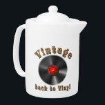 Tetera Vintage - De vuelta a Vinyl, el registro vuelve<br><div class="desc">El diseño presenta un estilizado registro de vinilo negro con ranuras realistas y un efecto brillante. La etiqueta media es roja y contiene las palabras "50, 60, 70, 80, 90" dispuestas en un círculo alrededor del medio - un homenaje a las décadas musicales. Por encima del registro, la palabra "Vintage"...</div>