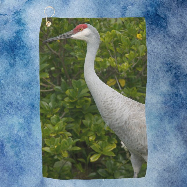 Toalla De Golf Fotografía de la grúa de la colina de arena de ave (A golf towel with a photograph of a sandhill crane bird in front of green leaves.)