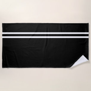 Toalla de playa negra con líneas blancas