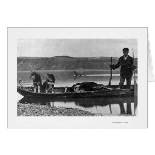 Trapper en canoa con pieles y perros Alaska