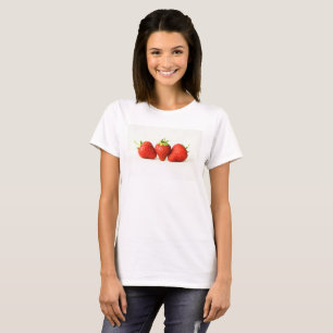Tres fresas sobre mujeres blancas con camiseta