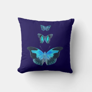 Tres mariposas azules en una almohada azul oscuro