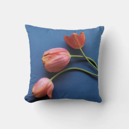 tulipanes de coral sobre almohada azul de tiro