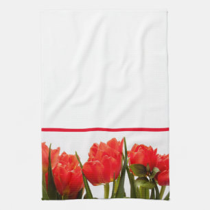 Tulipanes rojos en una toalla de cocina blanca sól