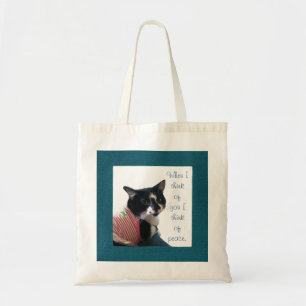 Un gato lindo de tuxedo piensa en las bolsas de lo