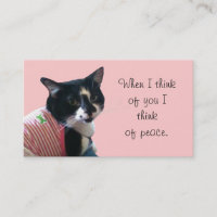 Un gato lindo de tuxedo piensa en tarjetas de nego