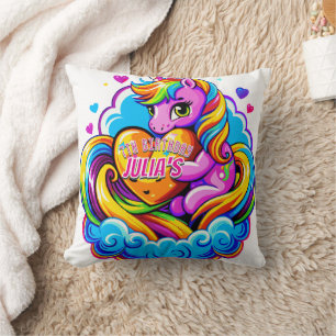 Un lindo unicornio abrazando una almohada cardíaca