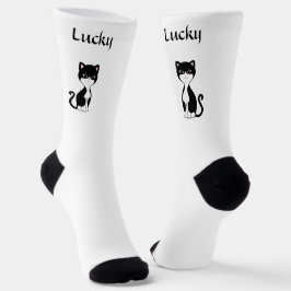 Un lindo y afortunado gato de Tuxedo en calcetines
