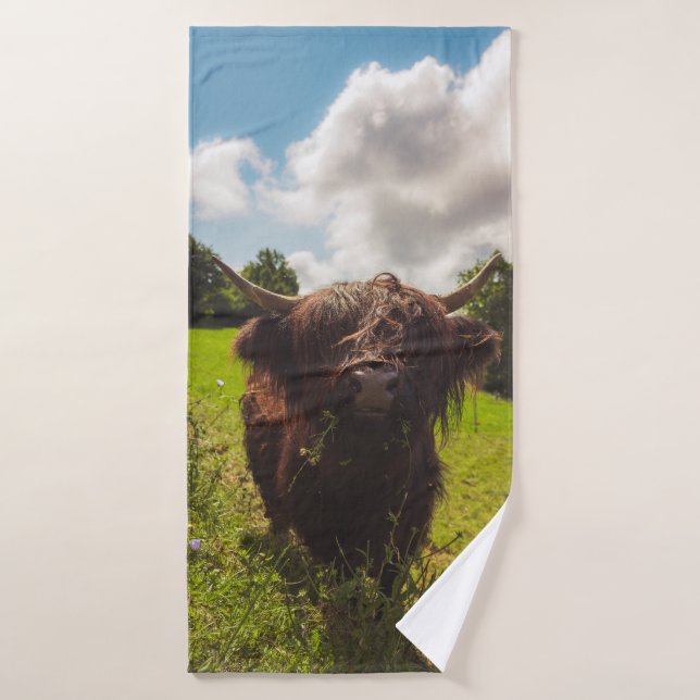 Vaca negra de tierras altas pastoreando verde luz  (Toalla de baño)