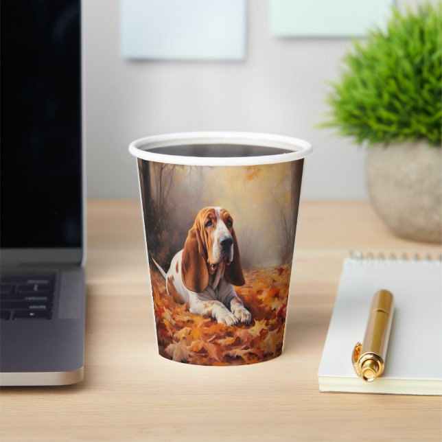 Vasos De Papel El óbice basset en las hojas de otoño se inspira (in situ)